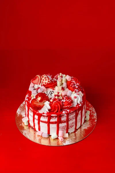 Valentines day cake with strawberry and heart shaped decorations on bright red background — Stock Photo, Image