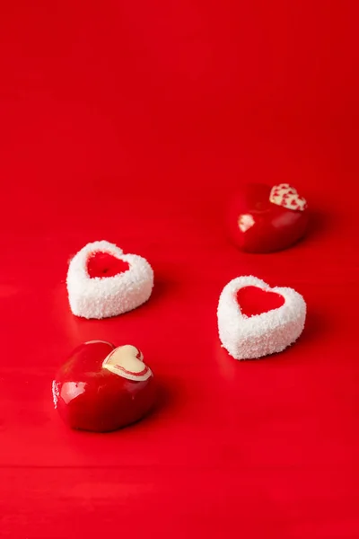 Heart shaped chocolate candies as a valentine's day seasonal present, top view shot on red background — Stock Photo, Image