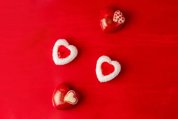 Heart shaped chocolate candies as a valentine's day seasonal present, top view shot on red background — Stock Photo, Image