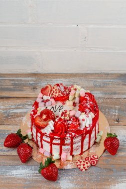 Sevgililer günü pastası, çilek, lokum ve mutfak masasında kalp şeklinde süslemeler.