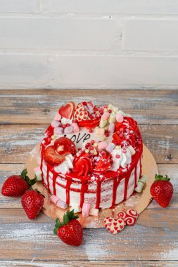 Sevgililer günü pastası, çilek, lokum ve mutfak masasında kalp şeklinde süslemeler.