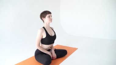 Stüdyoda yoga çalışmasından önce göğsünü ısıtan bir kadın.