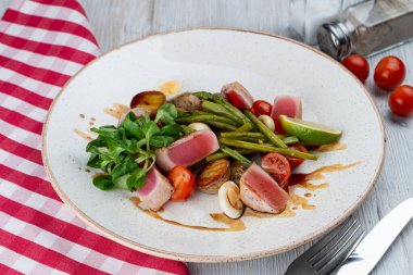 Orta pişmiş ton balığı bifteği fırında patates, yeşillik, yumurta ve fırında patates İtalyan restoranında sağlıklı bir akşam yemeği olarak.