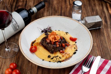 Kahverengi soslu dana yanakları ve parmesanlı peynirli polenta peyniri.