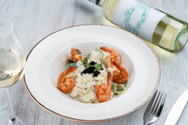 Zencefilli ve limonlu karidesli risotto, siyah havyarla süslenmiş.