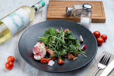 Hafif ve sağlıklı salata, çiğ somon, ıspanak, roka ve ahşap arka planda haşlanmış yumurta.