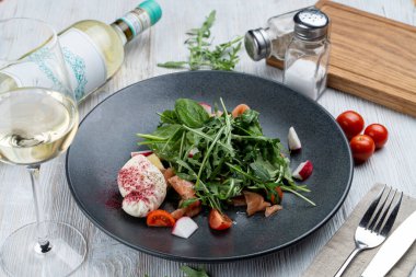 Hafif ve sağlıklı salata, çiğ somon, ıspanak, roka ve ahşap arka planda haşlanmış yumurta.