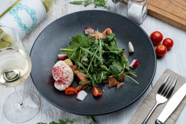 Hafif ve sağlıklı salata, çiğ somon, ıspanak, roka ve ahşap arka planda haşlanmış yumurta.