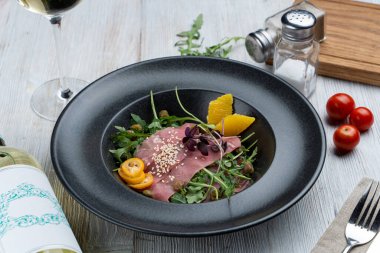 Kapari, roka ve portakallı Parma jambonu salatası.