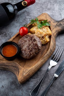 Biftek ve fırında patates rendelenmiş parmesan peyniri ve ahşap kesim tahtasının üzerinde hindistan cevizi.