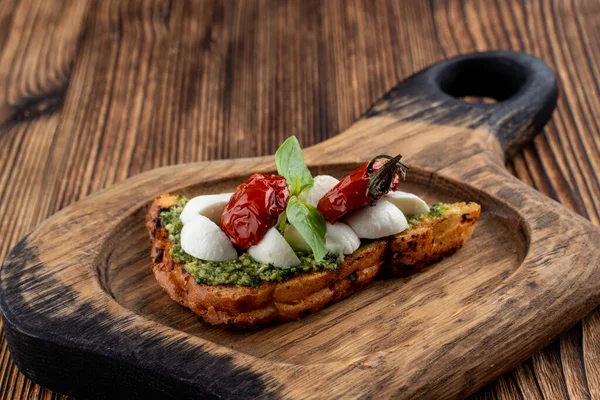 Bruschetta Con Pomodorini Secchi Mozzarella Pesto Ciabatta Tostata Croccante Servito — Foto Stock