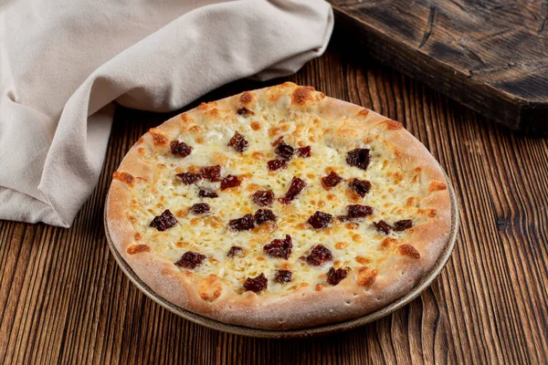 Sıcak Focaccia, kurutulmuş domates ve İtalyan restoranındaki ahşap masada mozzarella.