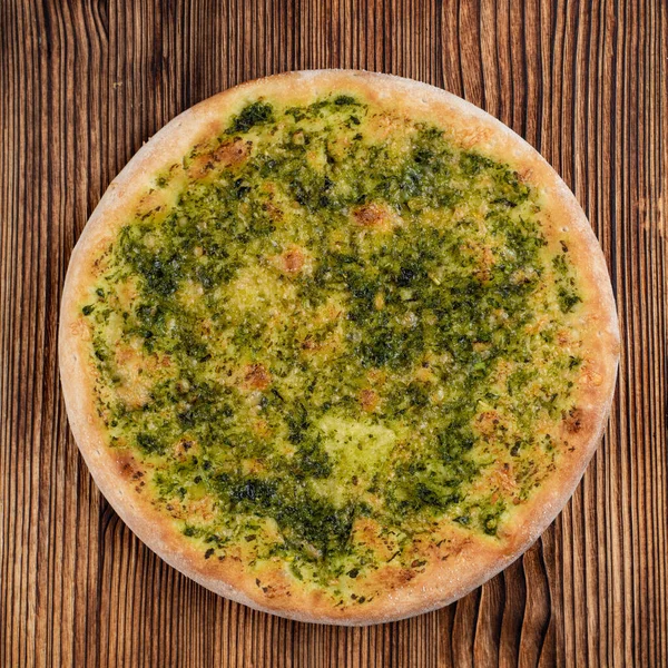 Aromatik pesto soslu buğday Focaccia ve ahşap arka planda rendelenmiş parmesan.