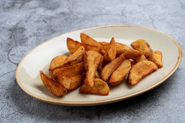 Baharatlı patates dilimleri bir kafede garnitür gibi