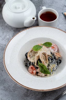 Karides, mürekkep balığı ve kremalı parmesan soslu siyah makarna.