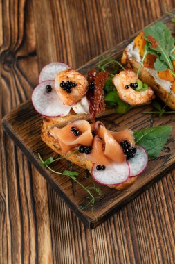 Kral karides bruschetta ile güneşte kurutulmuş domates ve kızarmış ekmeğin üzerinde guacamole.