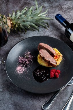 Fırında ananas, ahududu ve nar soslu ördek göğsünün üst görüntüsü. 