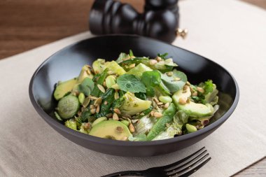 Lahanalı yeşil edamame salatası, avokado ve salatalık, yakın çekim.