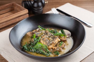 Haşlanmış deniz tarağı ve fındık soslu ıspanak ile marine edilmiş morina balığı.