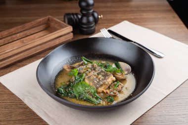 Haşlanmış deniz tarağı ve fındık soslu ıspanak ile marine edilmiş morina balığı.