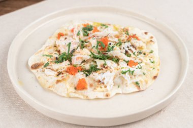 Yengeç etli, yeşil ve kırmızı havyarlı buğday gevrekli tortilla bir deniz ürünleri restoranında.