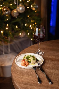 Şık bir restoranın masasında akşam vakti taze Çin lahanalı somon tartar ve bulanık ışıklar.