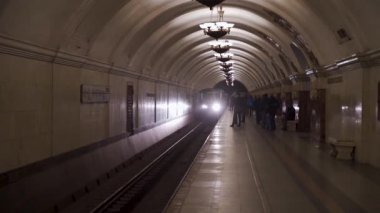 MOSCOW, 2020 yılının Nisan ayında Sovyet metrosunun iç kısımlarındaki karanlık bir tünelden istasyona gelen metro treni.