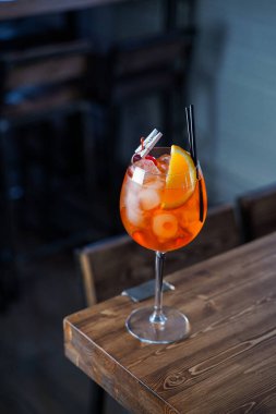 Tahta tezgahın üzerinde turuncu bir dilim Aperol spreyi, atmosferik çekim.