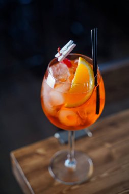Tahta tezgahın üzerinde turuncu bir dilim Aperol spreyi, atmosferik çekim.