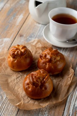 Geleneksel Rus köfteleri altın kabuklu, ahşap masada bir fincan çayla servis ediliyor.