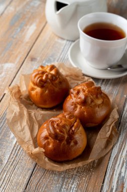Geleneksel Rus köfteleri altın kabuklu, ahşap masada bir fincan çayla servis ediliyor.