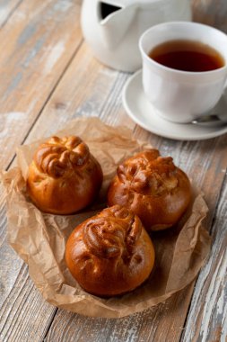 Geleneksel Rus köfteleri altın kabuklu, ahşap masada bir fincan çayla servis ediliyor.