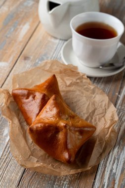 Geleneksel Rus köfteleri altın kabuklu, ahşap masada bir fincan çayla servis ediliyor.