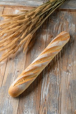 Tüm somun çavdar ekmeği ahşap zemin üzerinde ve buğday dikenleri etrafında