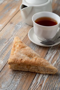 Bir fincan siyah çaya ikram olarak şekerli puf böreği üçgeni.