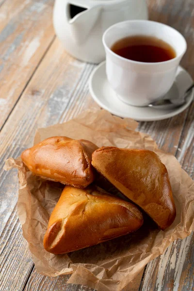 俄罗斯传统的填饱肚子的皮烤金皮 放在木制桌子上 上有一杯茶 — 图库照片