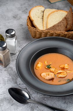 Somon, karides ve mürekkep balıklarıyla sıcak ve baharatlı deniz ürünleri çorbası. 