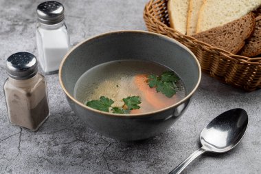 Bir kase sıcak tavuk suyu ve havuç. Çocuk menüsünün bir parçası. 