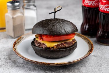 Peynirli siyah burger ve domuz çöreği, yakın çekim.