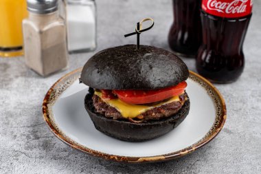 Peynirli siyah burger ve domuz çöreği, yakın çekim.