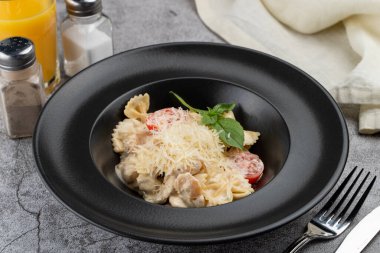 Krem soslu ve rendelenmiş parmesan peynirle süslenmiş tavuk göğsü.