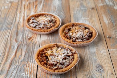 Ev yapımı fındıklı tart ve sade ahşap masada bal. 