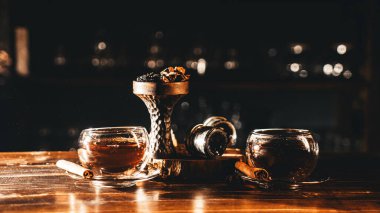 Tarçınlı baharatlı çay ve ahşap masada baharatlı oryantal shisha.