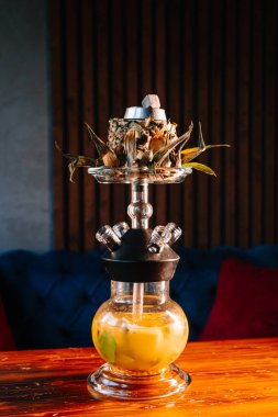 Dilimlenmiş ananaslı tatlı ananas shisha. Lobi barının karanlık doğu atmosferinde tütün kasesi gibi.