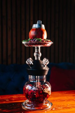 Shisha barında özel: arkaplanda meyve aromalı narlı nargile ve buzlu meyve suyu.