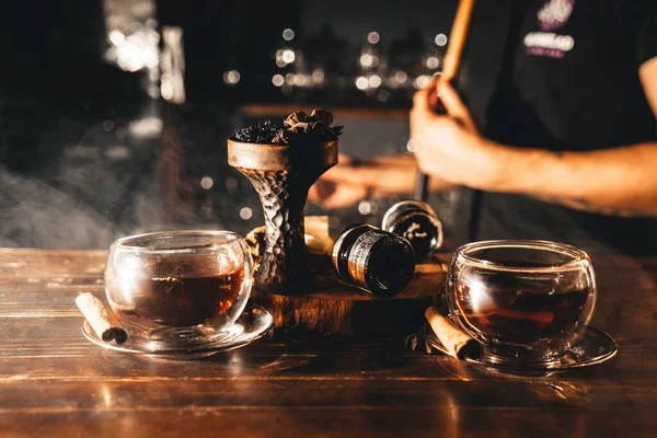 Spicy tea with cinnamon and anise with spicy oriental shisha on wooden table