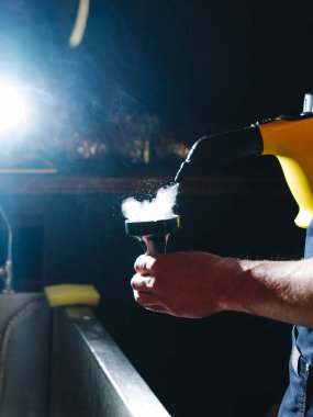 Adam nargileyi buharlı buharlı bir buharlı temizleyiciyle temizliyor.