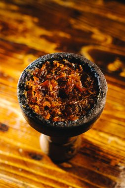 İçinde dilimlenmiş meyve tütünü olan kil nargile kaselerinin üst görüntüsü.