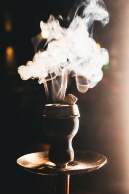 Shisha kasesinden fırlayan buhar kıvrımlar ve kıvrımlar, koyu arka planda, yumuşak yan ışık
