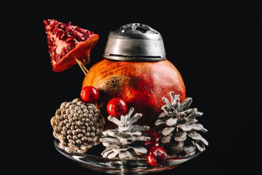Mevsimlik noel narları nargile siyah arka planda buzlu koniler, nar kâsesine yakın.